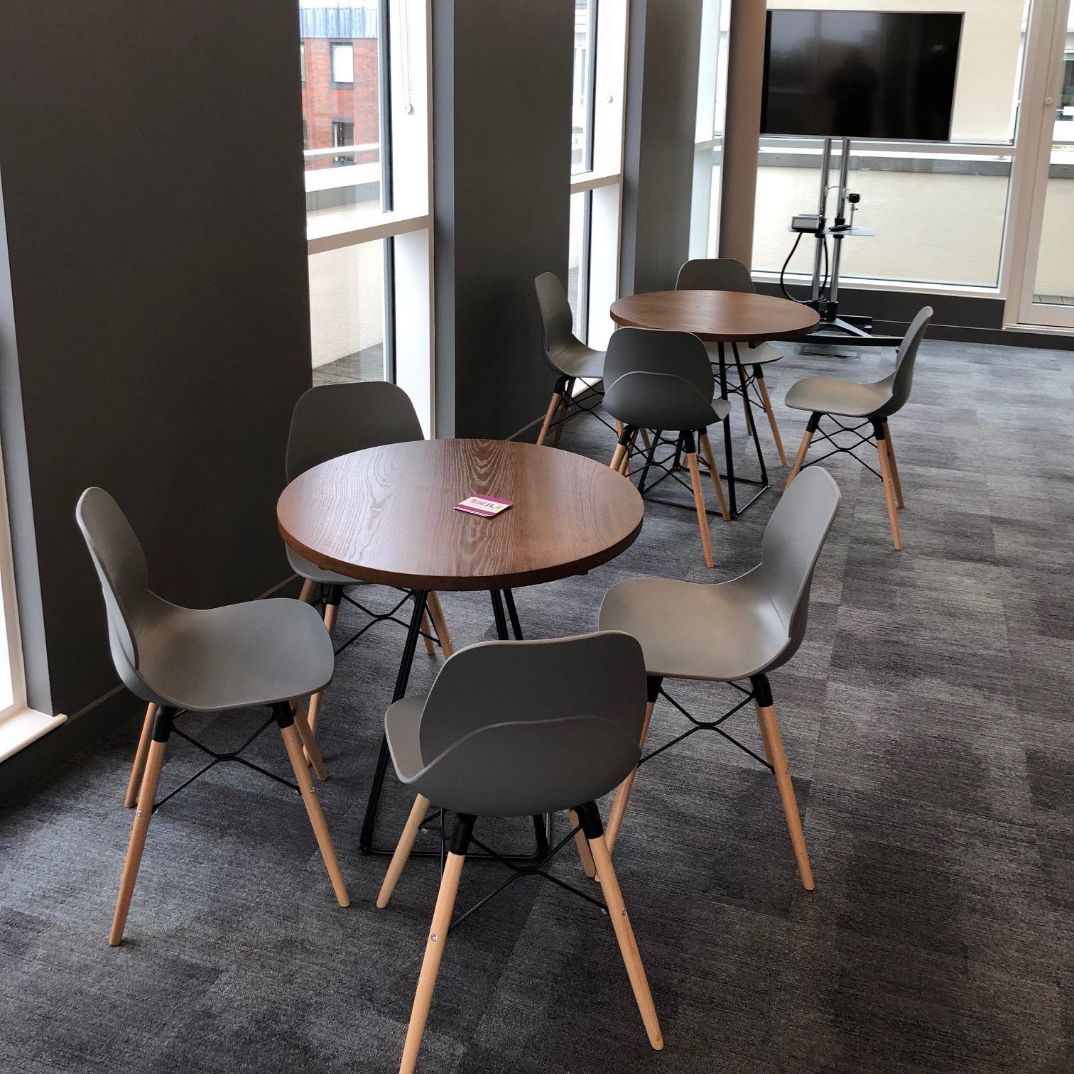 Commercial carpet tiles fitted in a bright breakout area with café tables